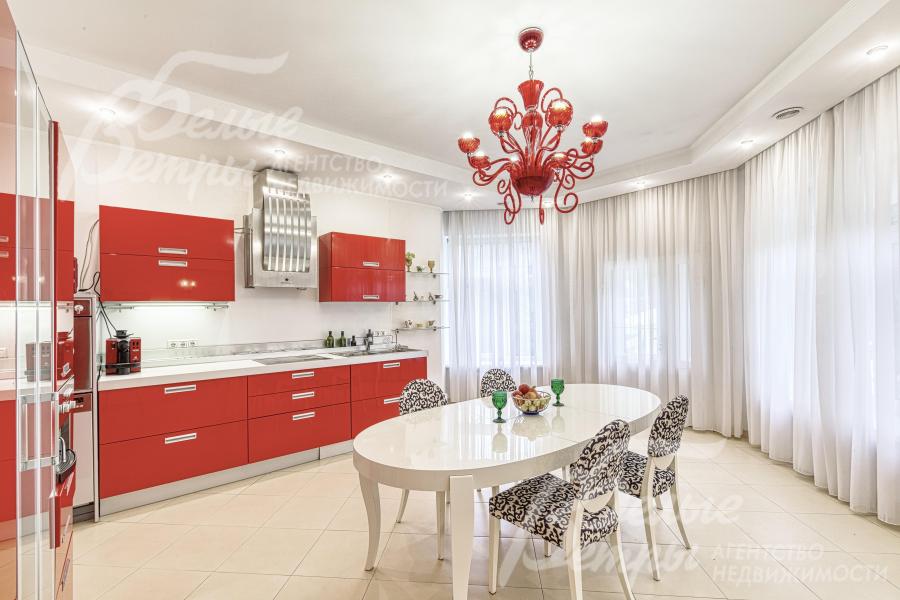 Кухню украшает дорогостоящая люстра красного оттенка в тон фасадов гарнитура