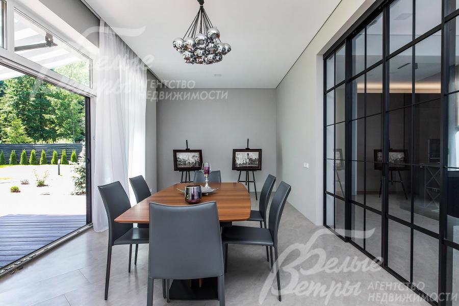 Столовая зона с панорамным остеклением и выходом на террасу