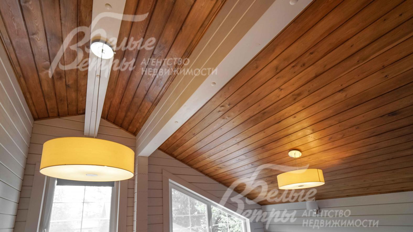 Потолок отделан красивый затонированной доской. Во всем доме - модные светильники 