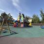 Площадка детского парка с качелями и игровым городком