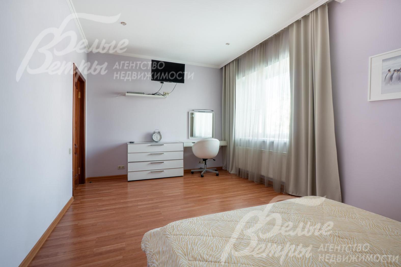 Рядом с комодом у окна расположен удобный туалетный столик