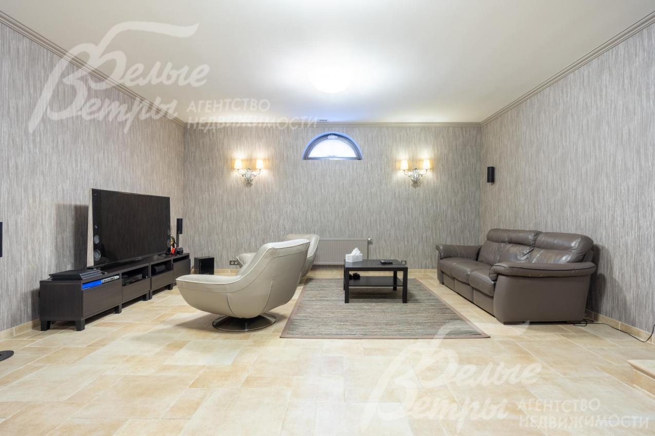 Комната отдыха спа-зоны (на цокольном этаже) с домашним кинотеатром, диваном и удобными креслами