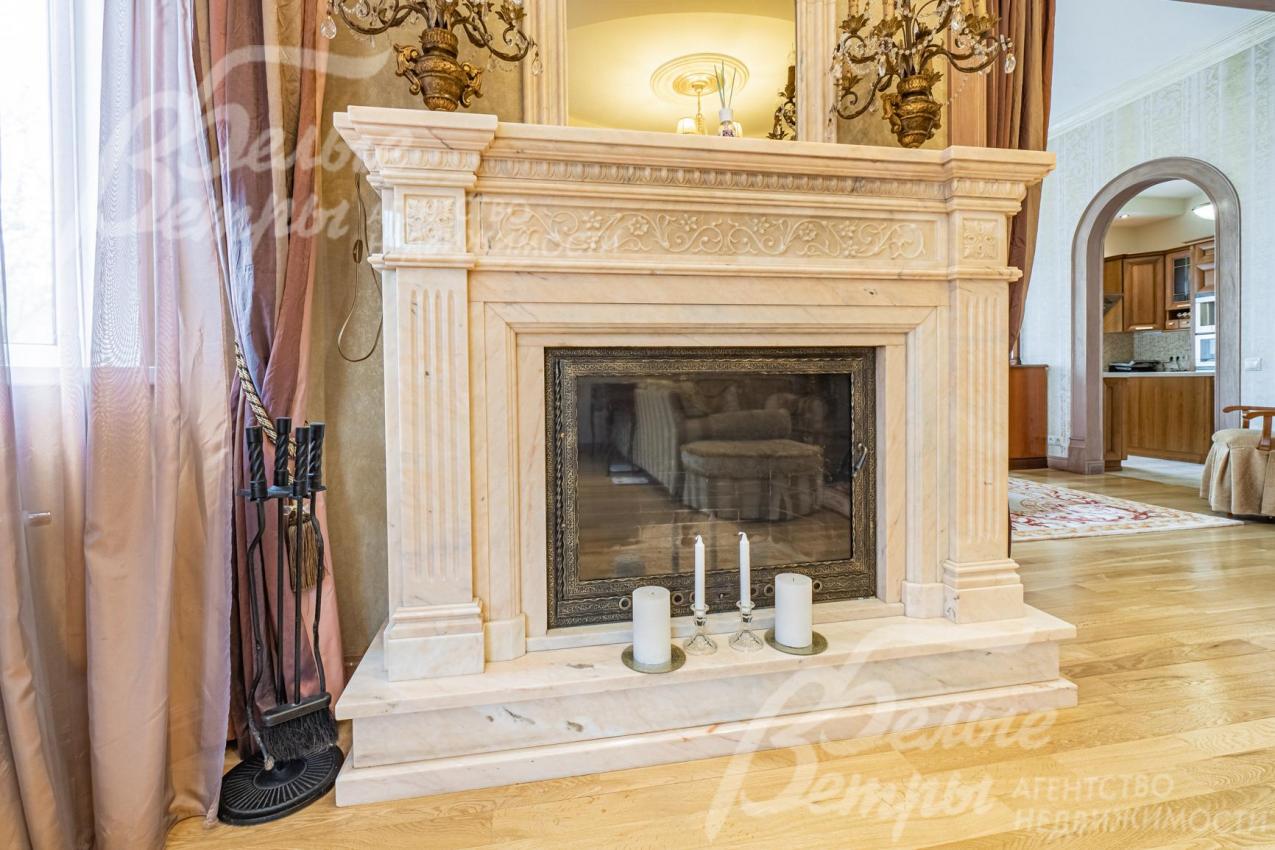 Камин отделан розовым мрамором