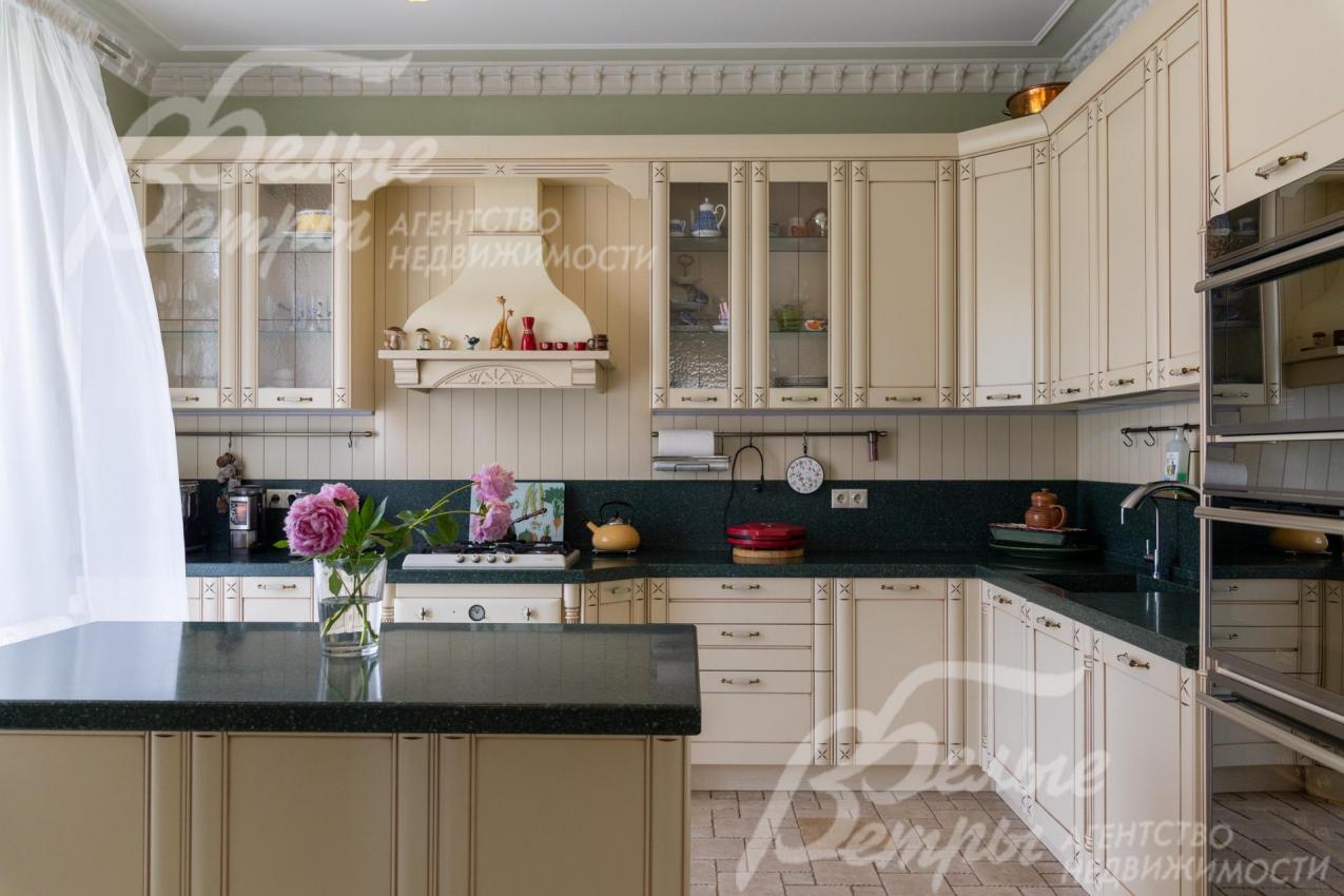 Кухня из массива дерева с островом с полубарной стойкой и всей необходимой встроенной бытовой техникой