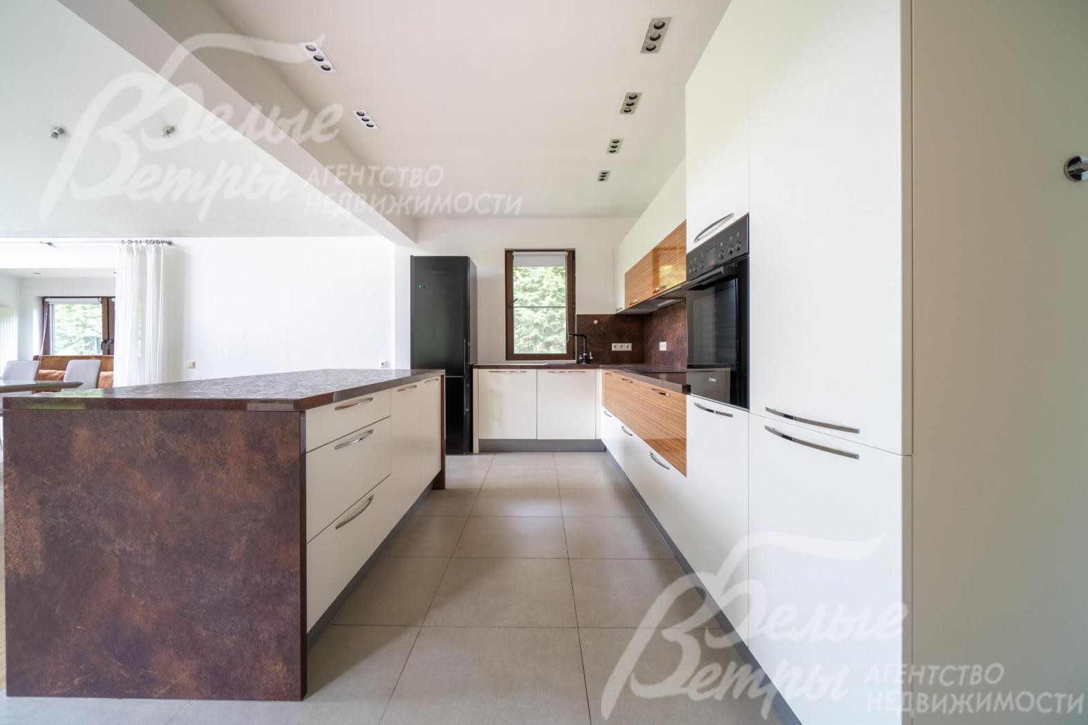 На кухне - гарнитур с полубарным островом и вся необходимая встроенная техника