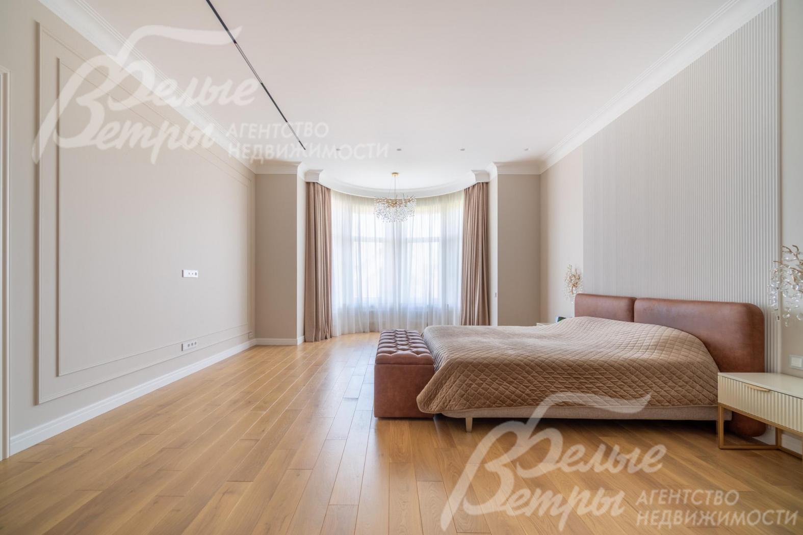 Мастер-спальня с эркером, стены декорированы молдингами, у изголовья - 3D-панель