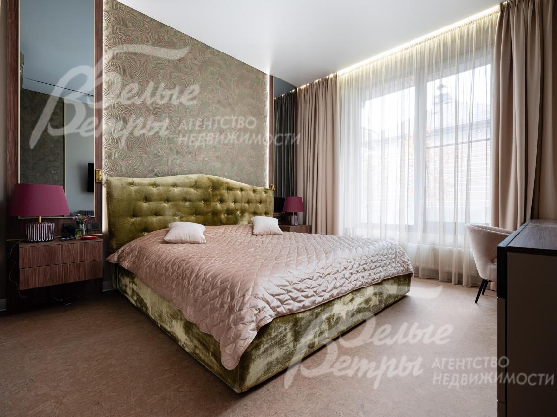 Мастер-спальня на первом этаже с большим окном и спальным гарнитуром