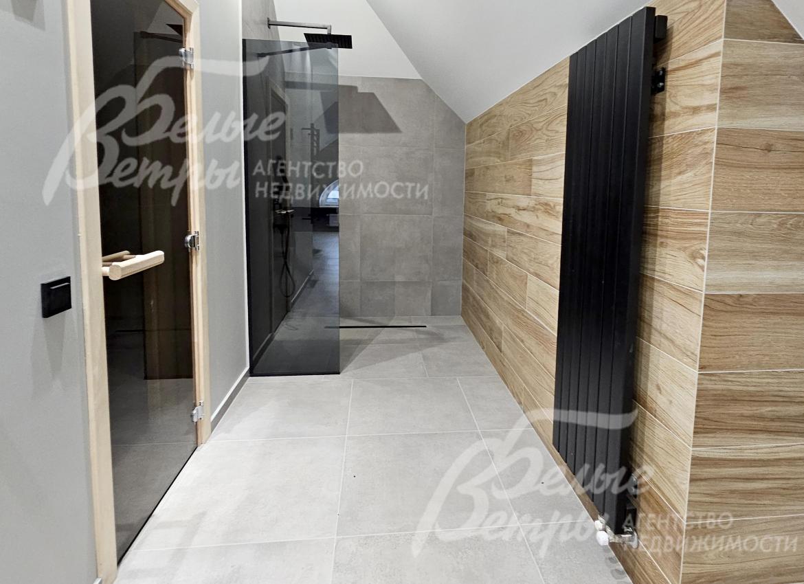 Спа-зон на мансардном этаже: слева - сауна и душевая, справа - дизайнерский радиатор чёрного цвета