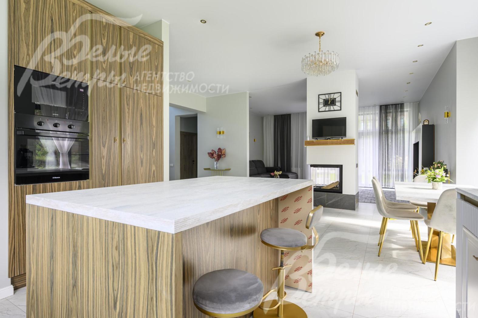 На кухне — гарнитур от российской фабрики Ziti Cucine. Фасады — с фрезеровкой, рамками и каннелюрами, столешница из ДСП в оттенке выбеленного дуба