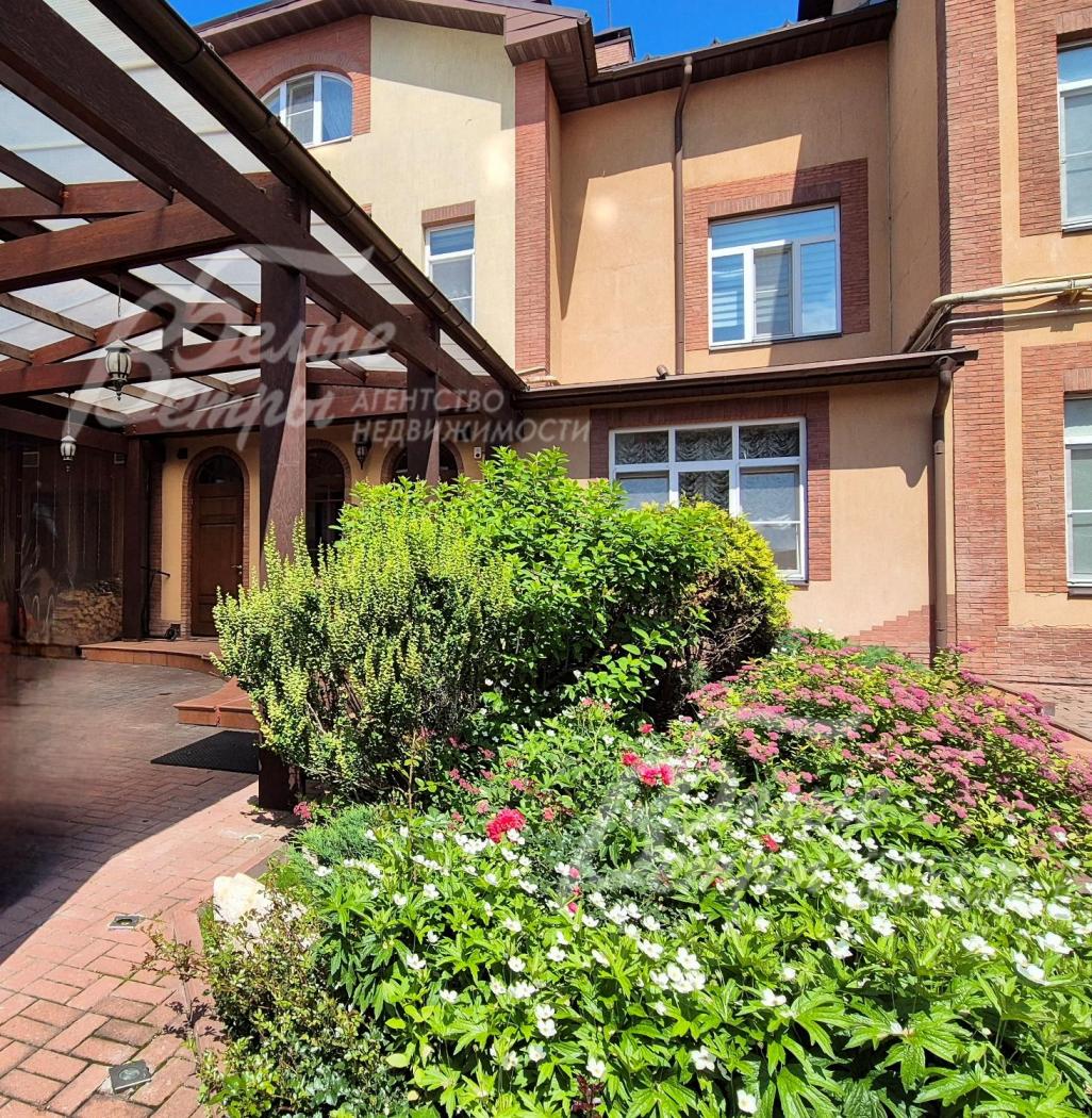 Входную группу украшает живая изгородь из цветника.