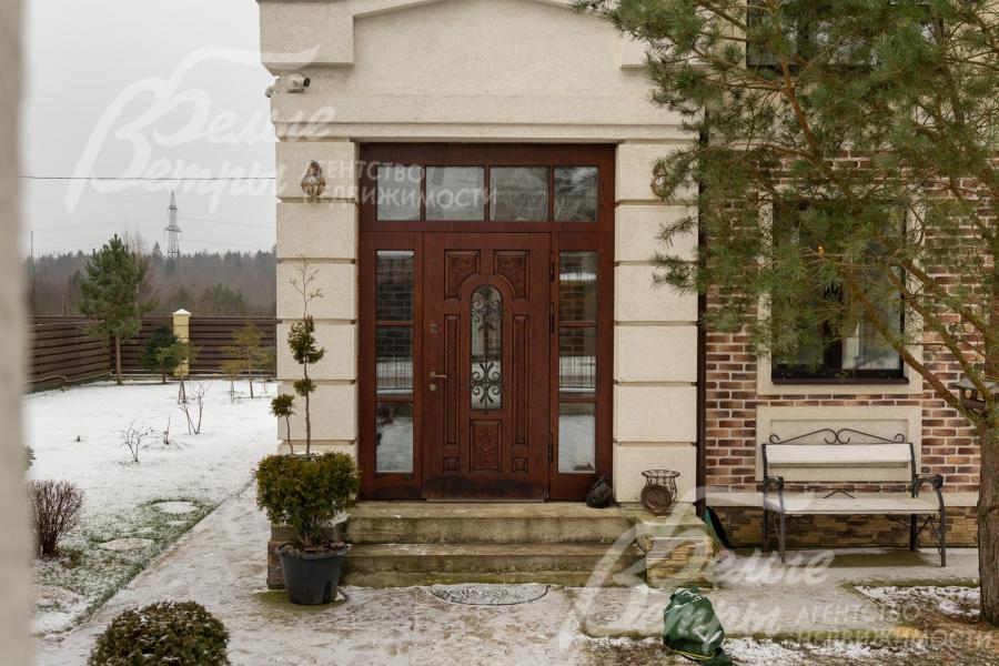 Установлена входная дверь со стеклянными вставками, перед входом высажена взрослая сосна, создающая выразительный акцент