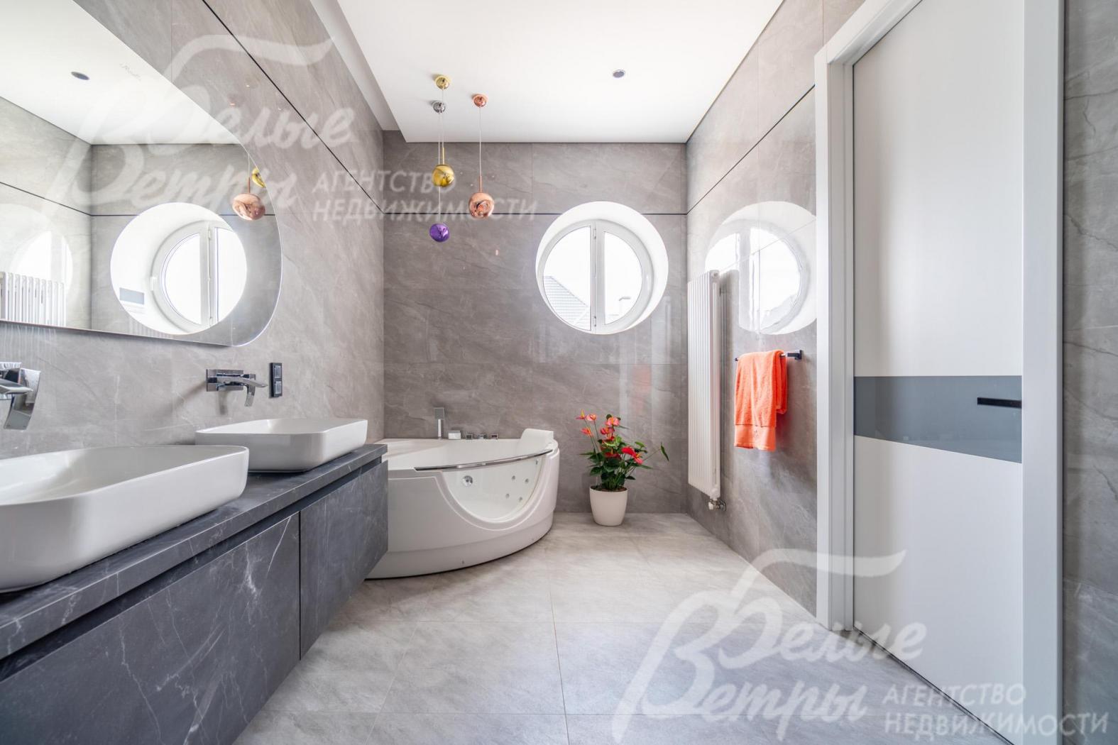 В санузле мастер-спальни -  полукруглая угловая ванна с гидромассажем B&W и круглое окно