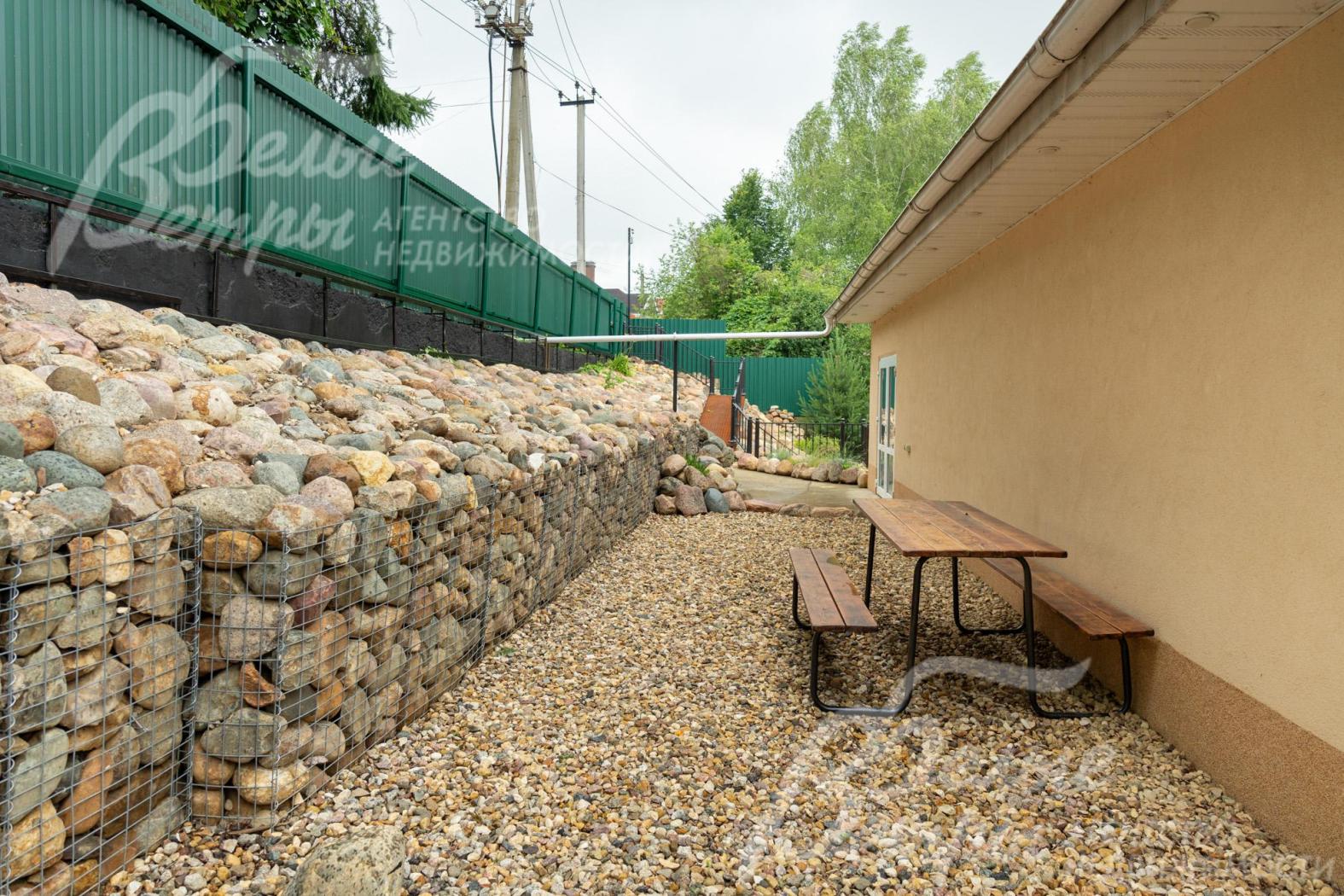 Садовый столик со скамьями на летней террасе второго уровня 