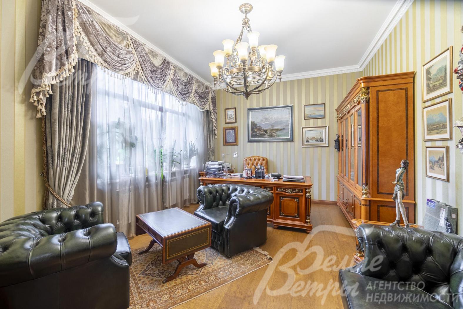 Представительский кабинет с безупречным деловым стилем: кожаная мягкая мебель, шкаф и стол из массива дерева