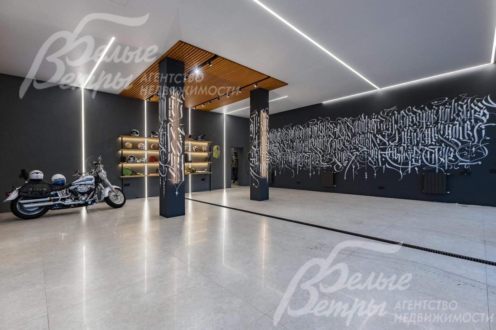 Тёплый гараж на первом этаже, рассчитанный на 3 автомобиля, с оригинальной отделкой стен