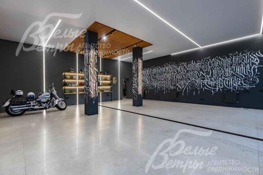 Тёплый гараж на первом этаже, рассчитанный на 3 автомобиля, с оригинальной отделкой стен