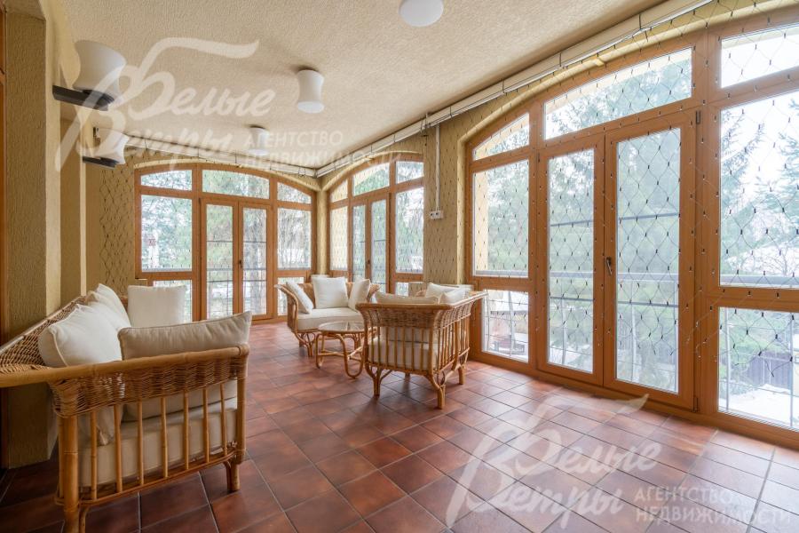 На террасе - стена с подогревом, большая площадь остекления, комплект плетёной мебели