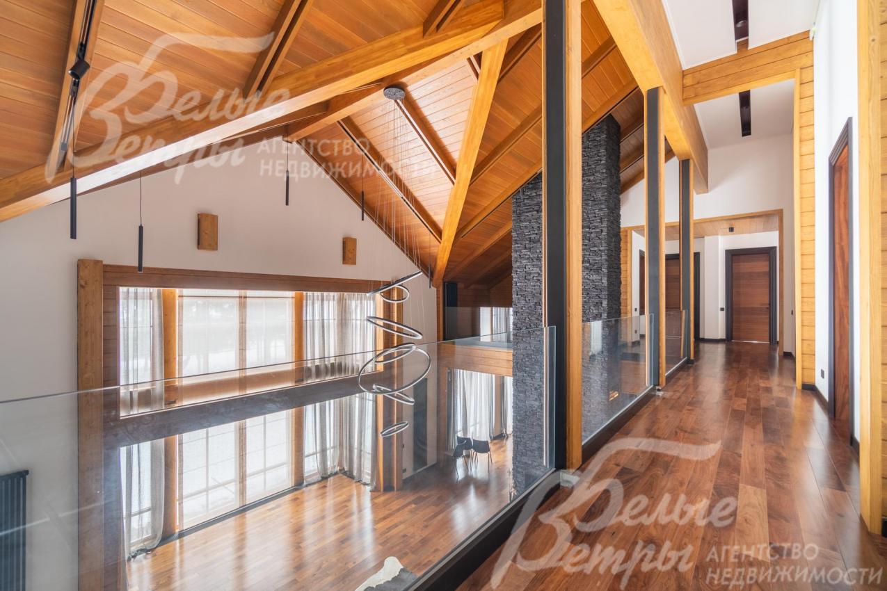 Холл второго этажа над гостиной со вторым светом: отделка подчёркивает природную тематику интерьера