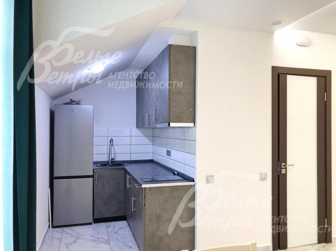 Компактная зона кухни в студии на втором этаже