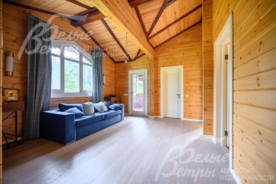 Холл 2-го этажа банного комплекса с диваном и выходом на балкон