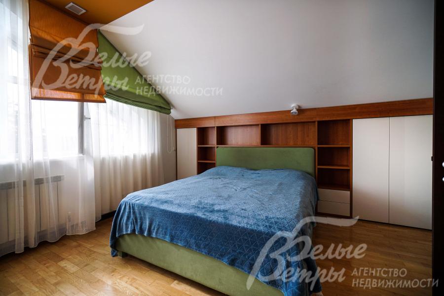 Мастер-спальня на мансардном этаже. У изголовья кровати интегрированы вместительные стеллажи и шкафы