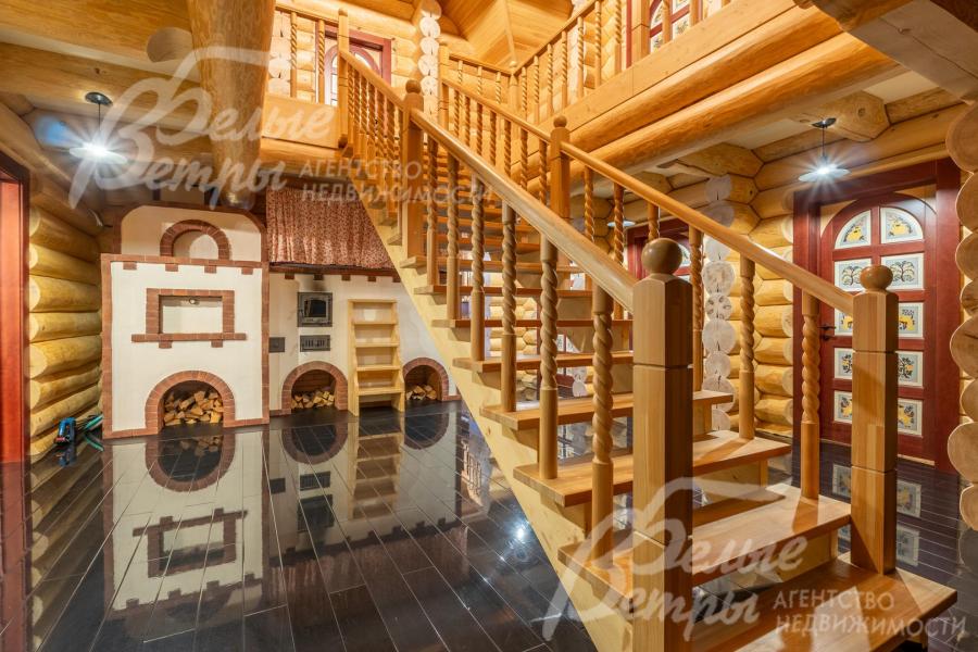 На второй этаж ведёт статная лестница из массива дерева с декоративными резными балясинами