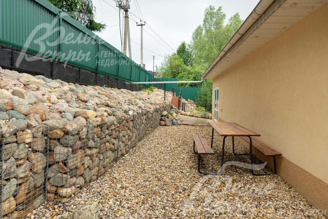 Садовый столик со скамьями на летней террасе второго уровня 