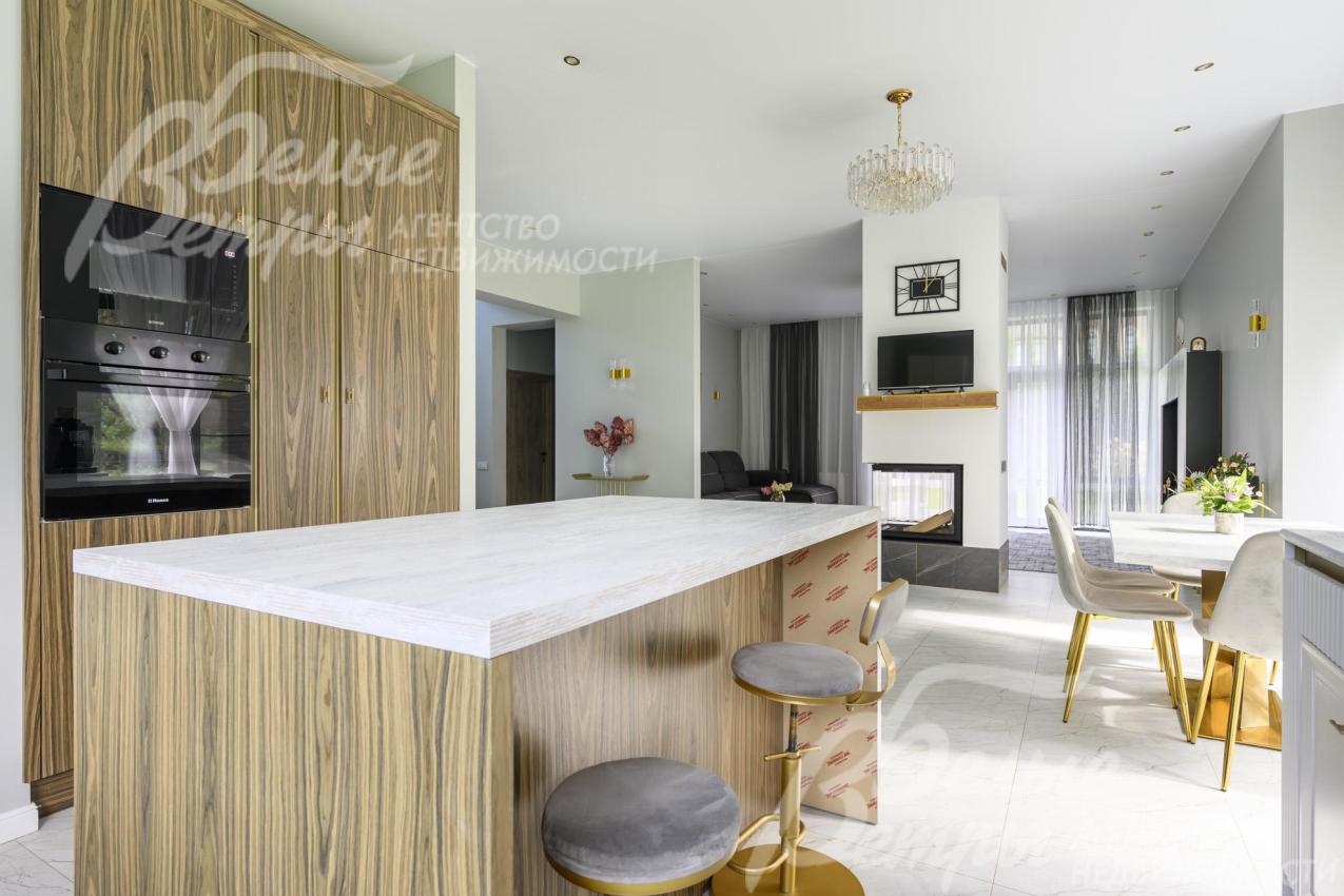 На кухне — гарнитур от российской фабрики Ziti Cucine. Фасады — с фрезеровкой, рамками и каннелюрами, столешница из ДСП в оттенке выбеленного дуба