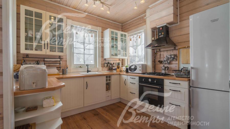 Кухонный гарнитур в светлых тонах со столешницей из массива дерева, со встроенной техникой