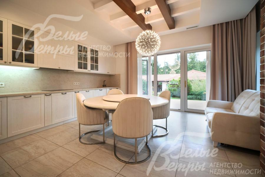 Меблированная светлая кухня с панорамным окном и выходом на террасу