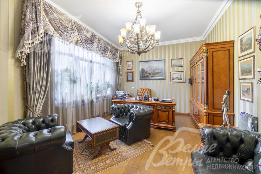 Представительский кабинет с безупречным деловым стилем: кожаная мягкая мебель, шкаф и стол из массива дерева