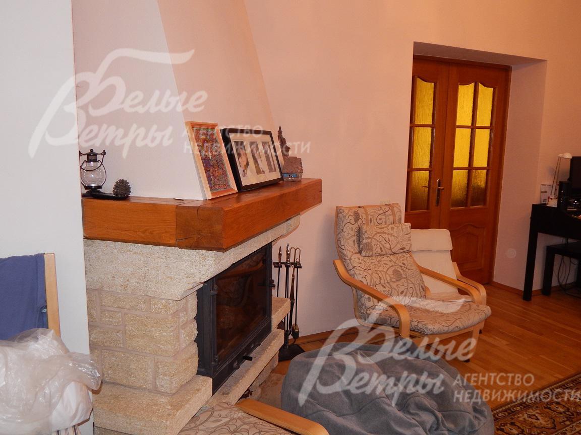 Камин отделан натуральным камнем и деревом, имеет стеклянную жаростойкую дверцу