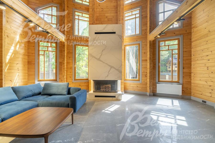 Гостиная залита светом - множество красиво оформленных окно.