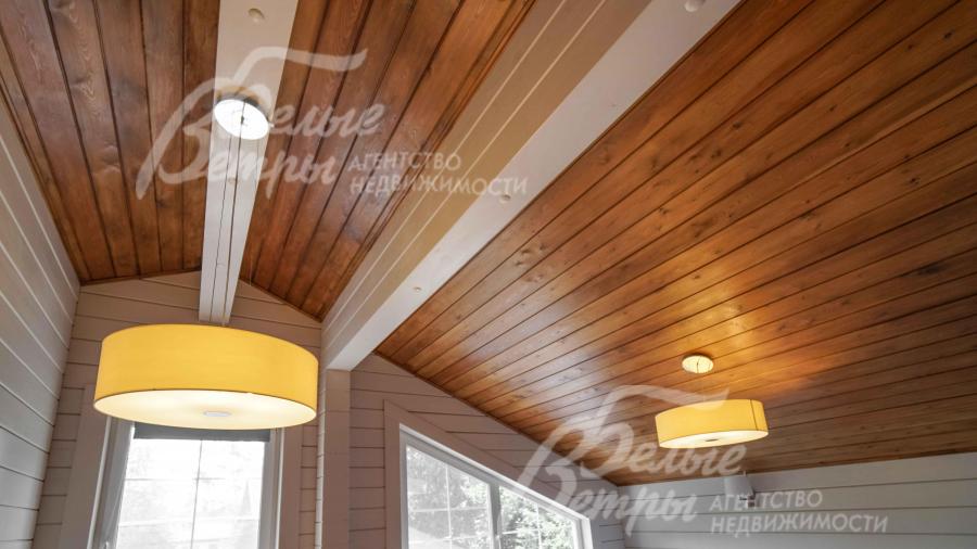 Потолок отделан красивый затонированной доской. Во всем доме - модные светильники 