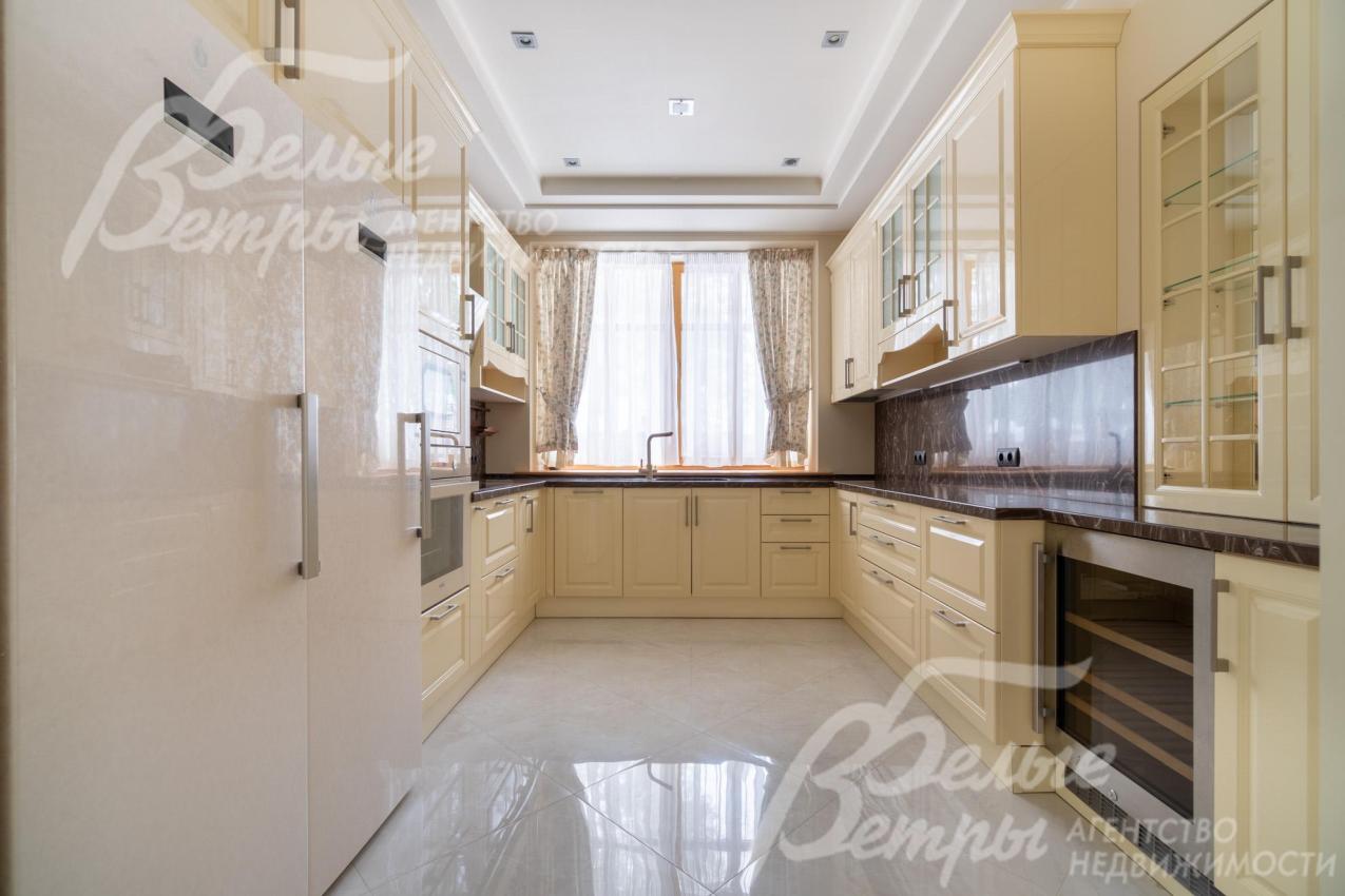 Главная кухня, расположенная в отдельном помещении, укомплектована гарнитуром в бежево-кремовых тонах и бытовой техникой