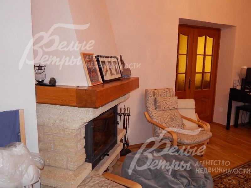 Камин отделан натуральным камнем и деревом, имеет стеклянную жаростойкую дверцу