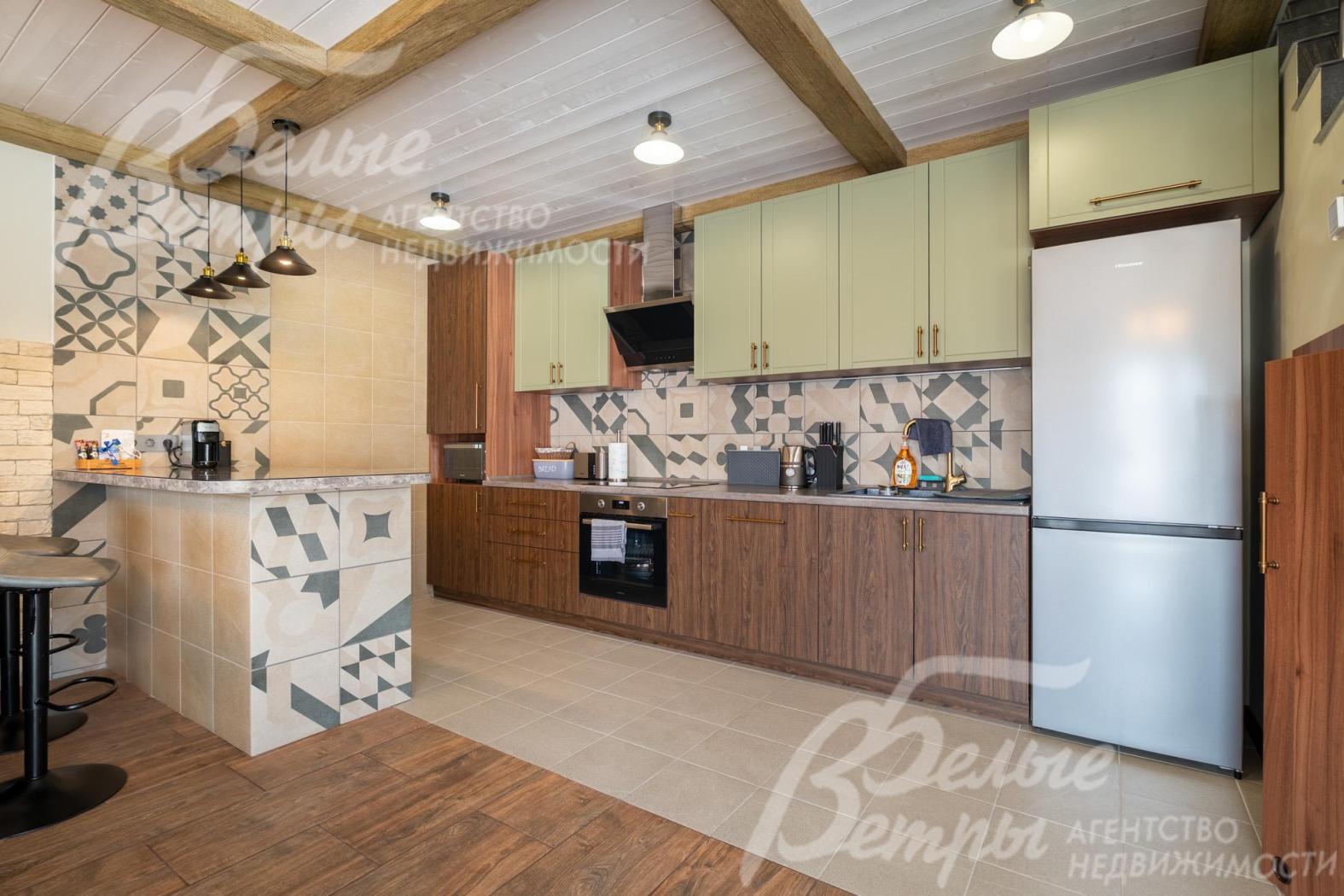 В доме - собственная кухня-столовая с полубарным островом и гарнитуром со встраиваемой техникой 