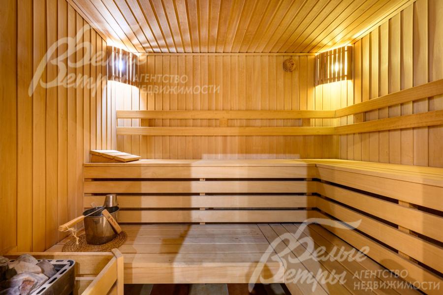 Стены сауны обшиты доской из липы, полки - из абаша, печь выложена из кирпича