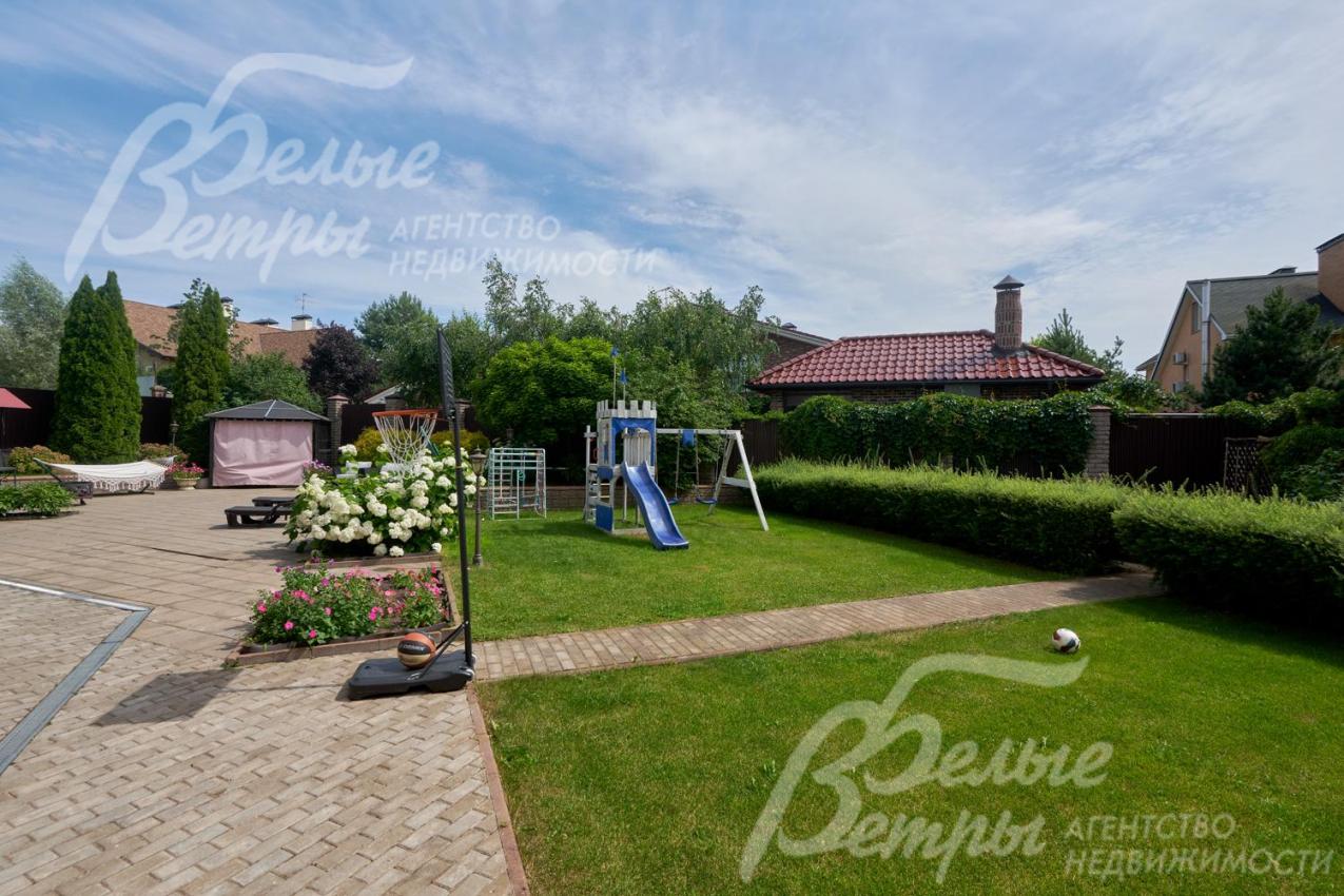 Дом стоит на живописном зелёном участке с профессиональным ландшафтным дизайном