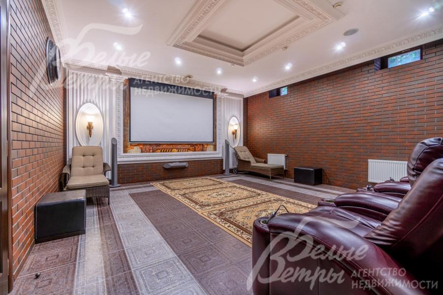 Просторный кинотеатр на цокольном этаже: установлены кресла  с реклайнерам, экран шириной 2,75 м