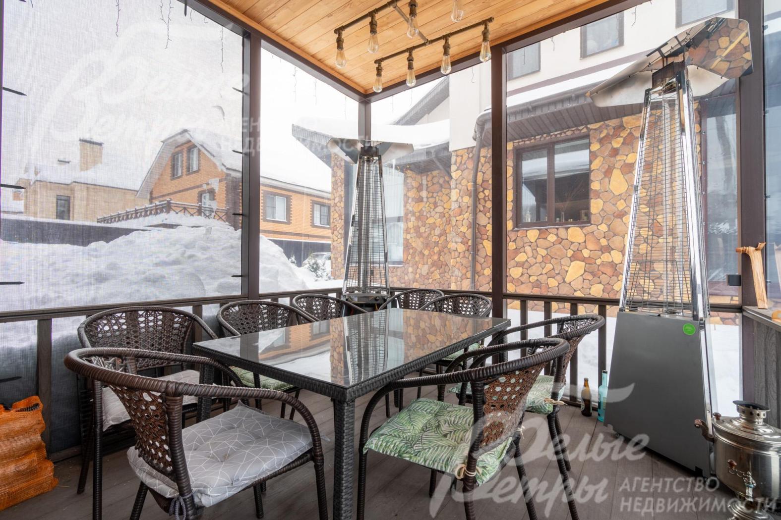 В беседке установлена садовая мебель, конструкция закрывается мягким стеклом