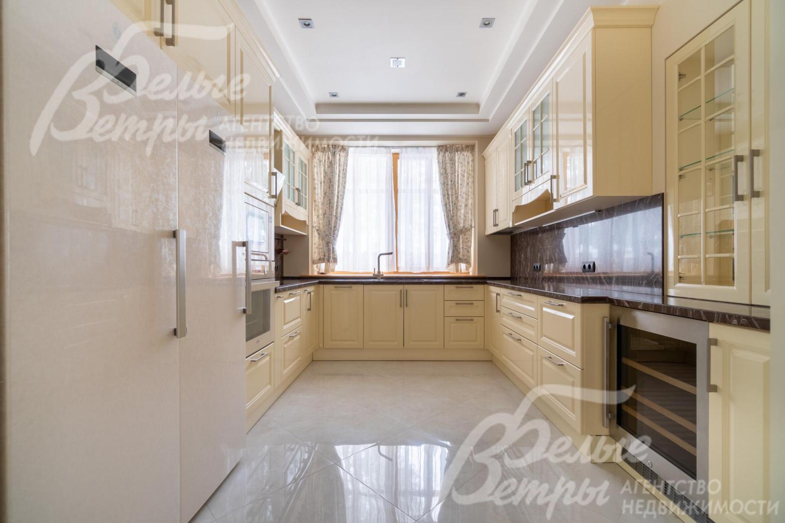 Главная кухня, расположенная в отдельном помещении, укомплектована гарнитуром в бежево-кремовых тонах и бытовой техникой