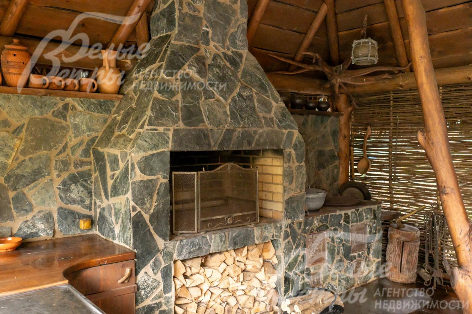 Впечатляющий мангал из природного камня дополнен практичной дровницей