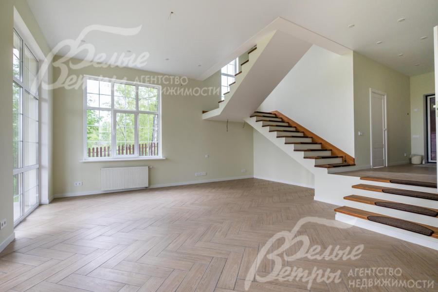 Широкая монолитная лестница, ступени отделаны деревом.