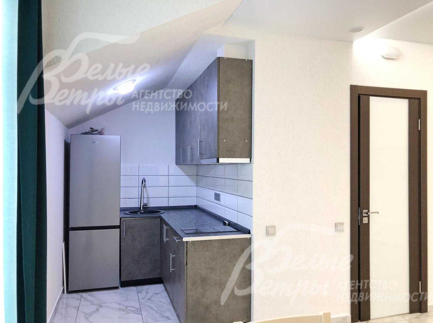 Компактная зона кухни в студии на втором этаже