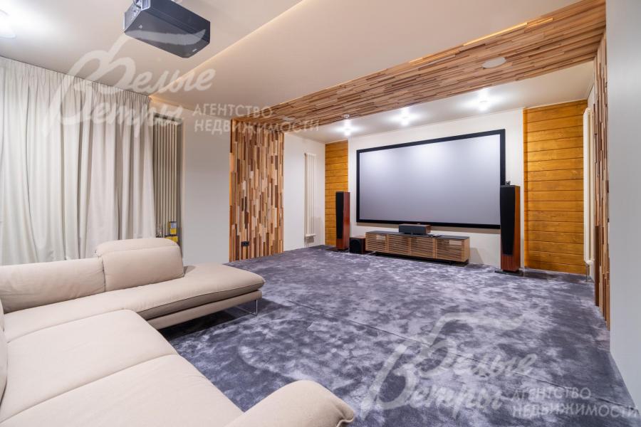 На первом этаже - кинотеатр с экраном 135″. Панно из ценных пород создают выразительные акценты в лестничном холле и кинозале