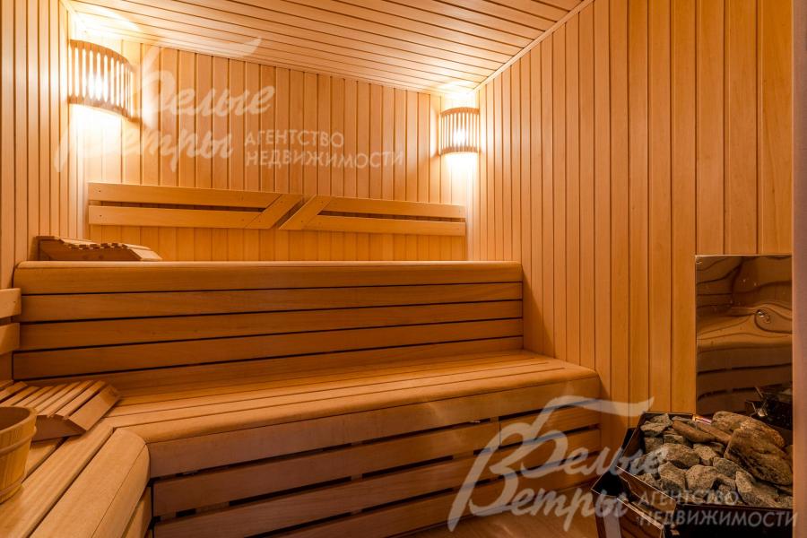 Сауна на первом этаже, полки отделаны абашем