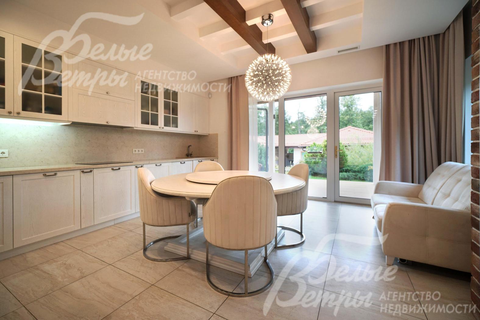 Меблированная светлая кухня с панорамным окном и выходом на террасу