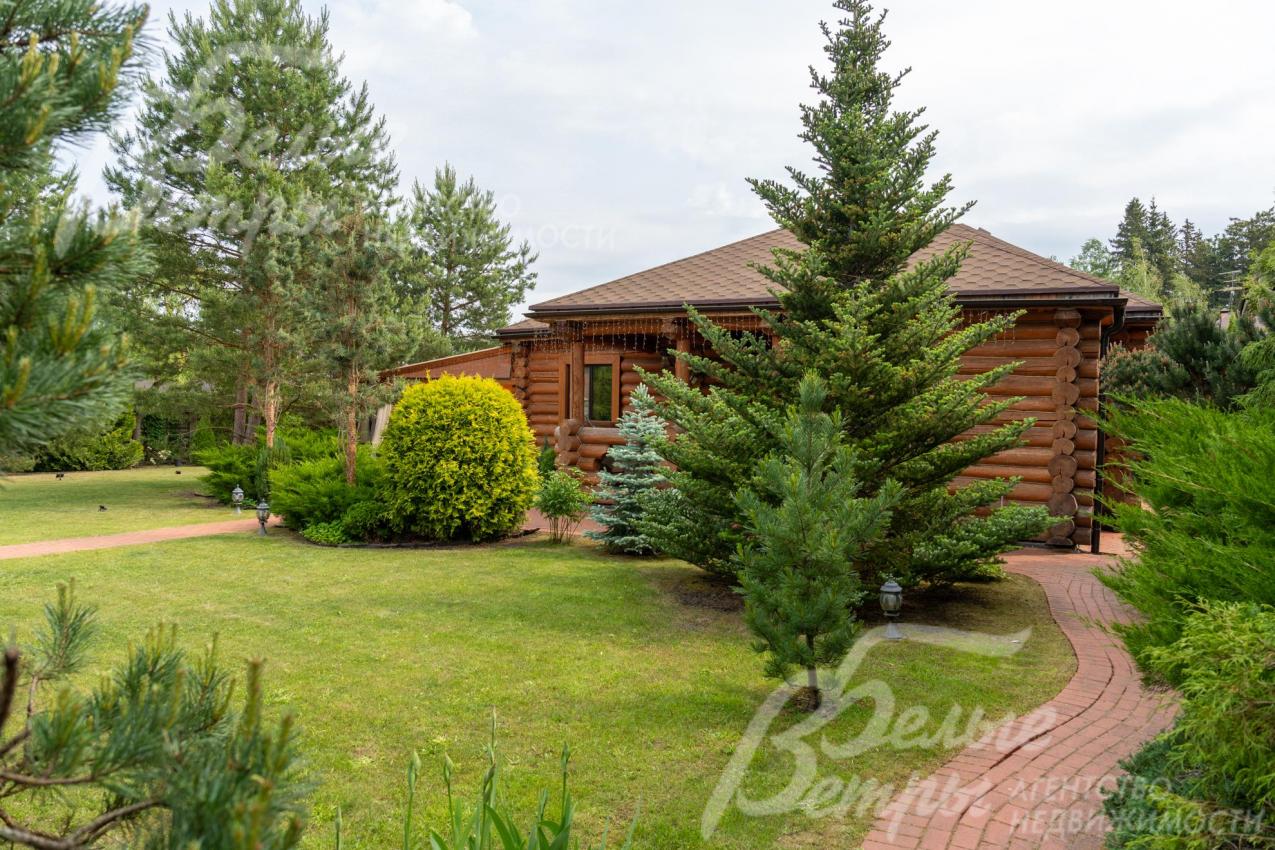 На участке выполнен проект ландшафтного дизайна с лесными деревьями.