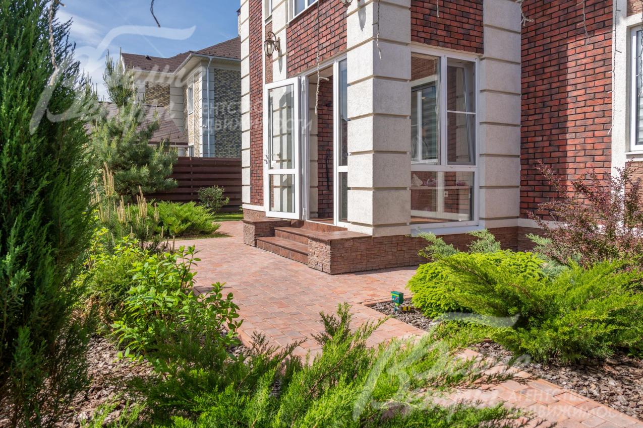 Облицовка дома - штукатурка, искусственный камень под кирпич, вход через остекленный тамбур